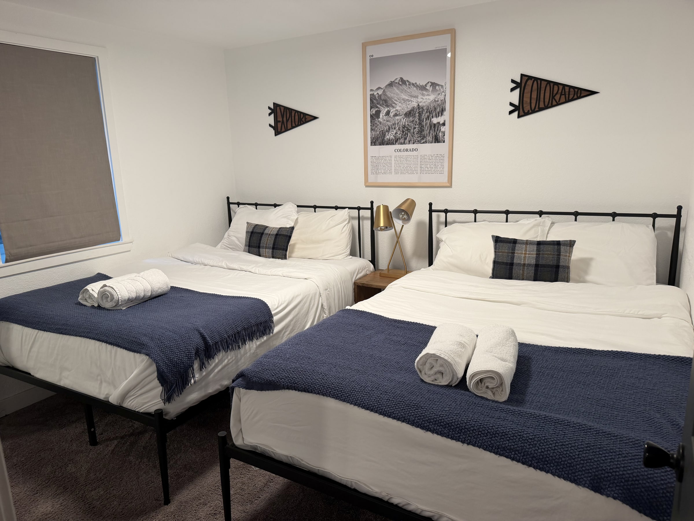 Guest bedroom with two neatly made beds and folded towels