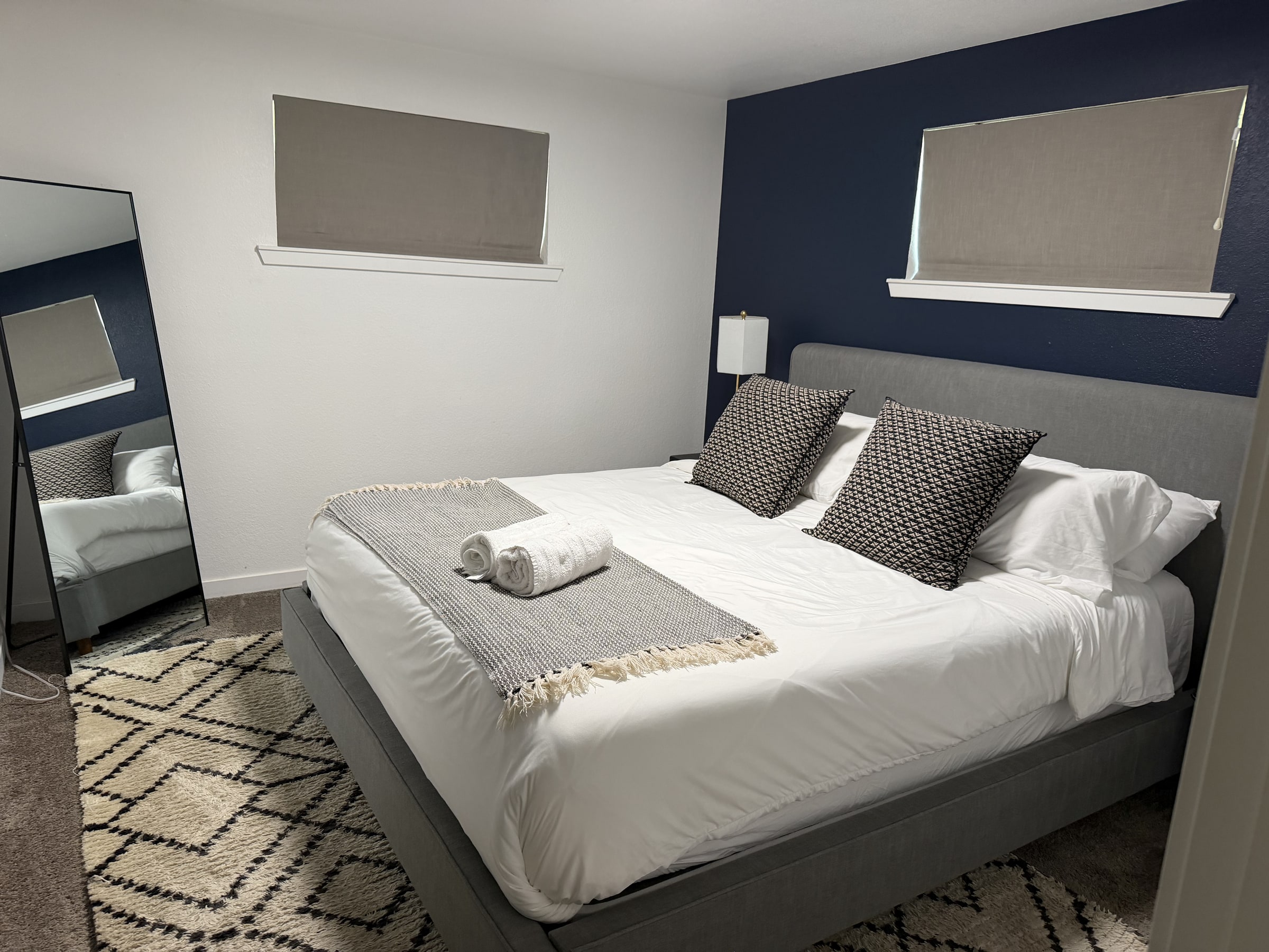 Bedroom with navy accent wall and crisp white bedding