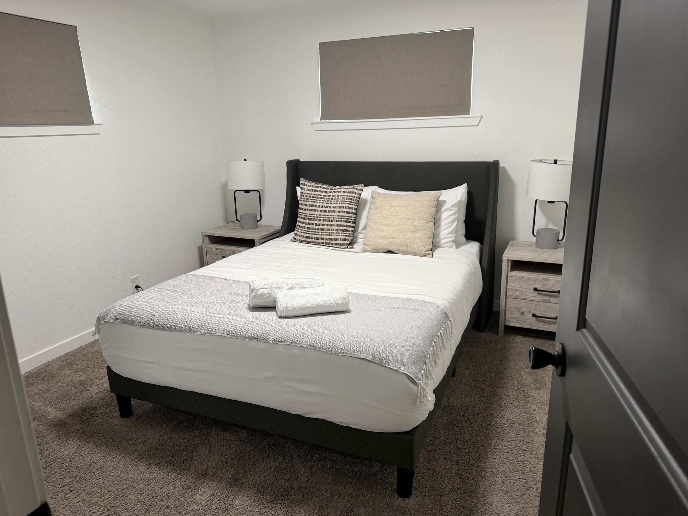 Minimal guest bedroom with white bedding and folded towel