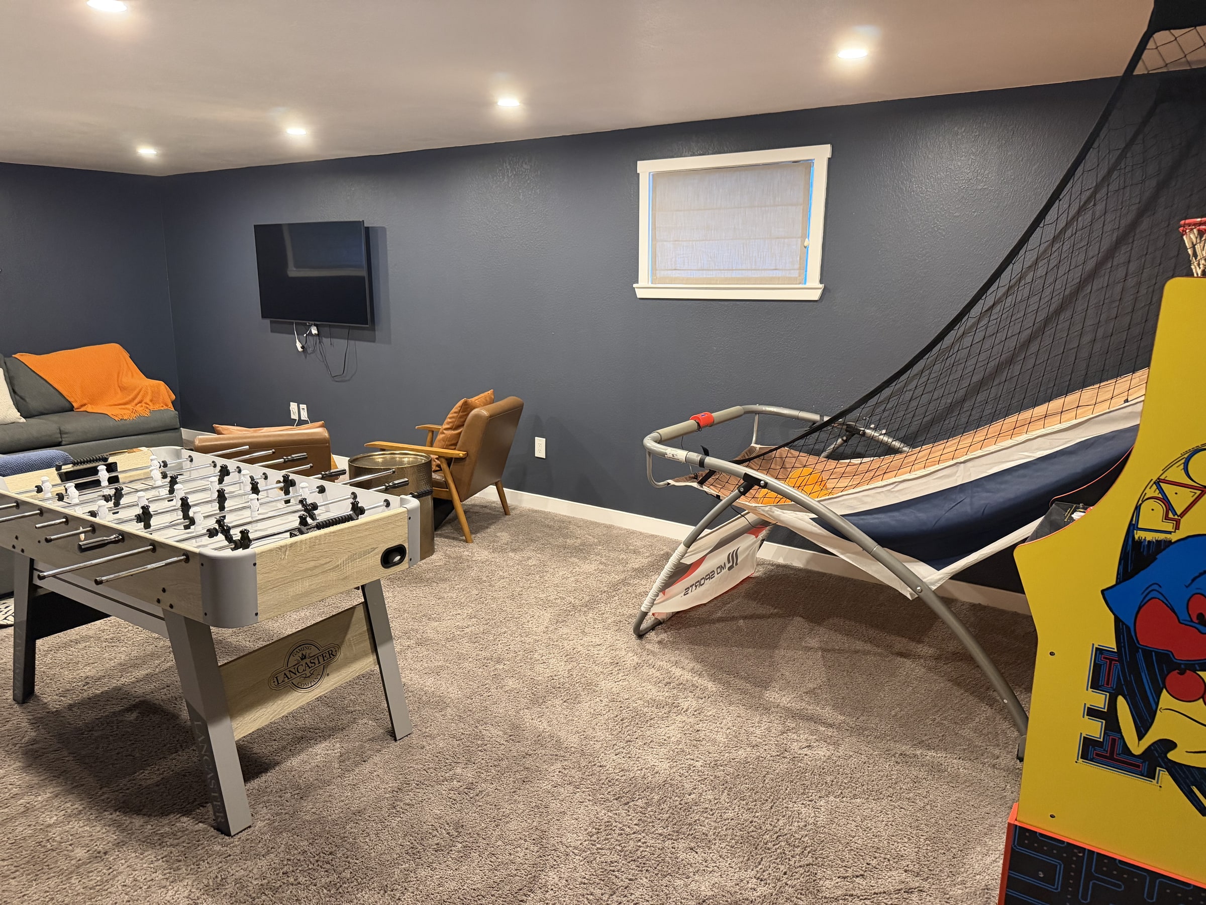 Game lounge with sectional sofa, foosball table, and hammock chair