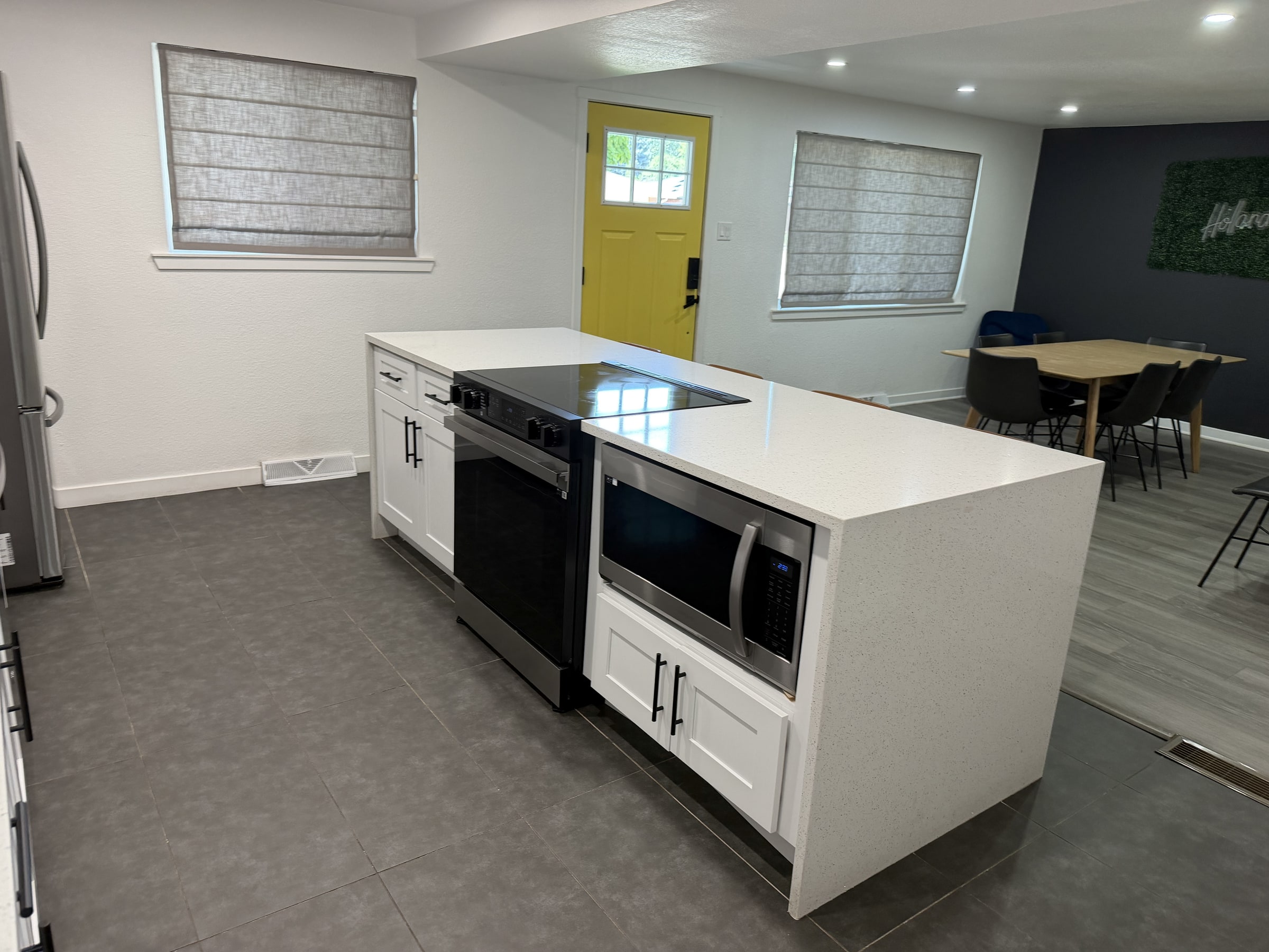 Clean lower-level kitchen island with bright door and open room