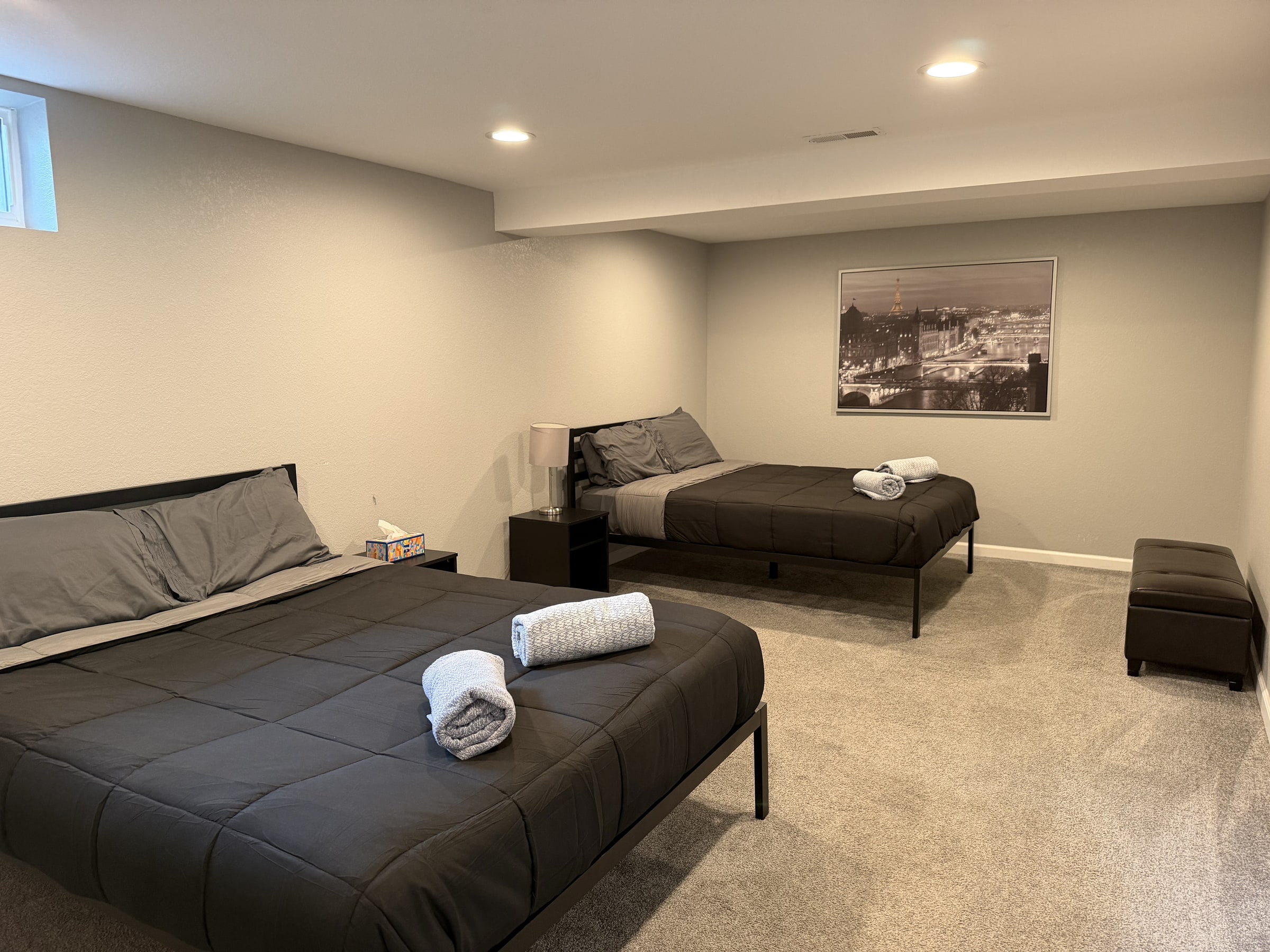 Clean lower-level sitting and sleeping area with folded towel