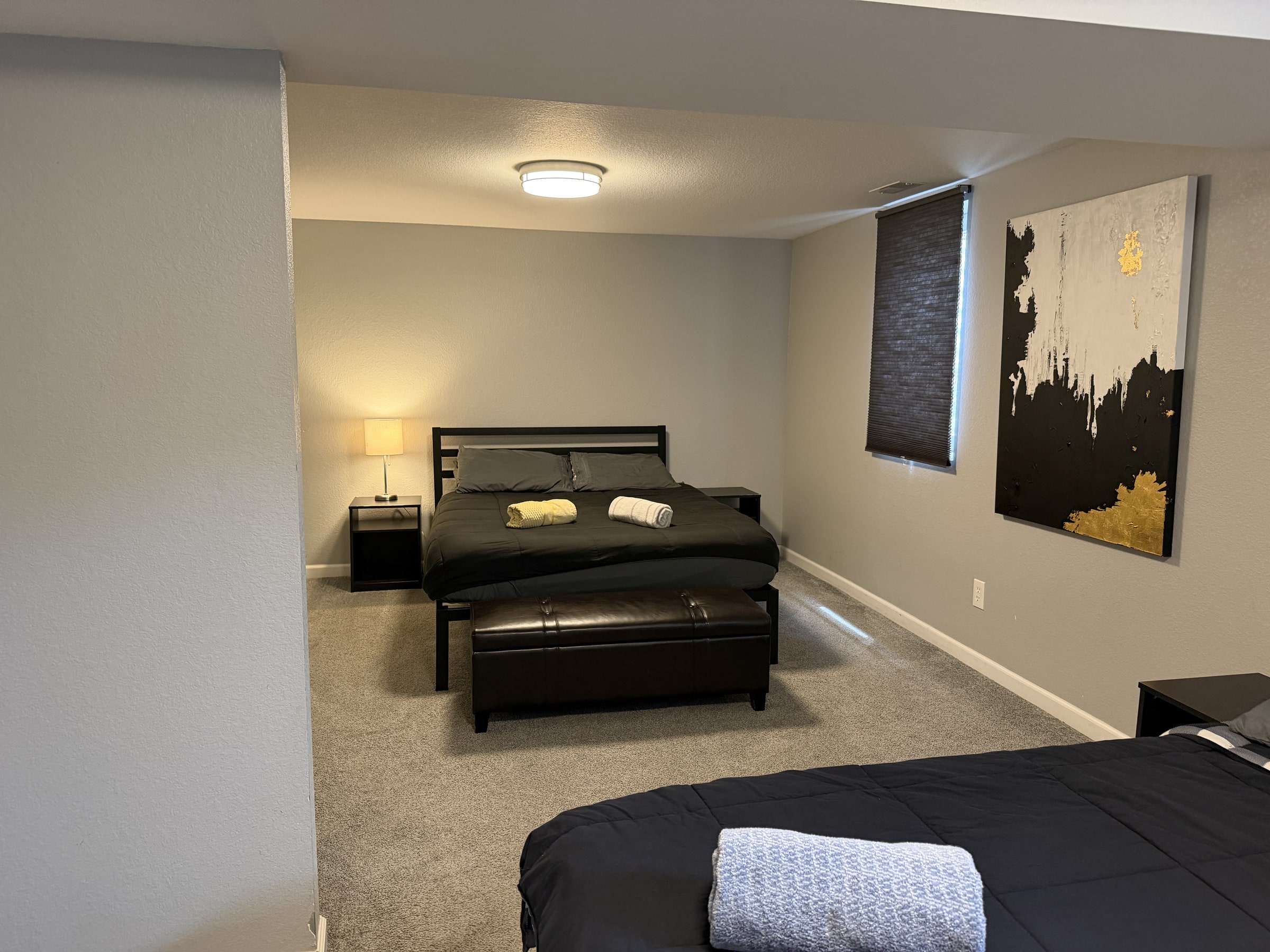 Lower-level bedroom and sitting area with clean bedding