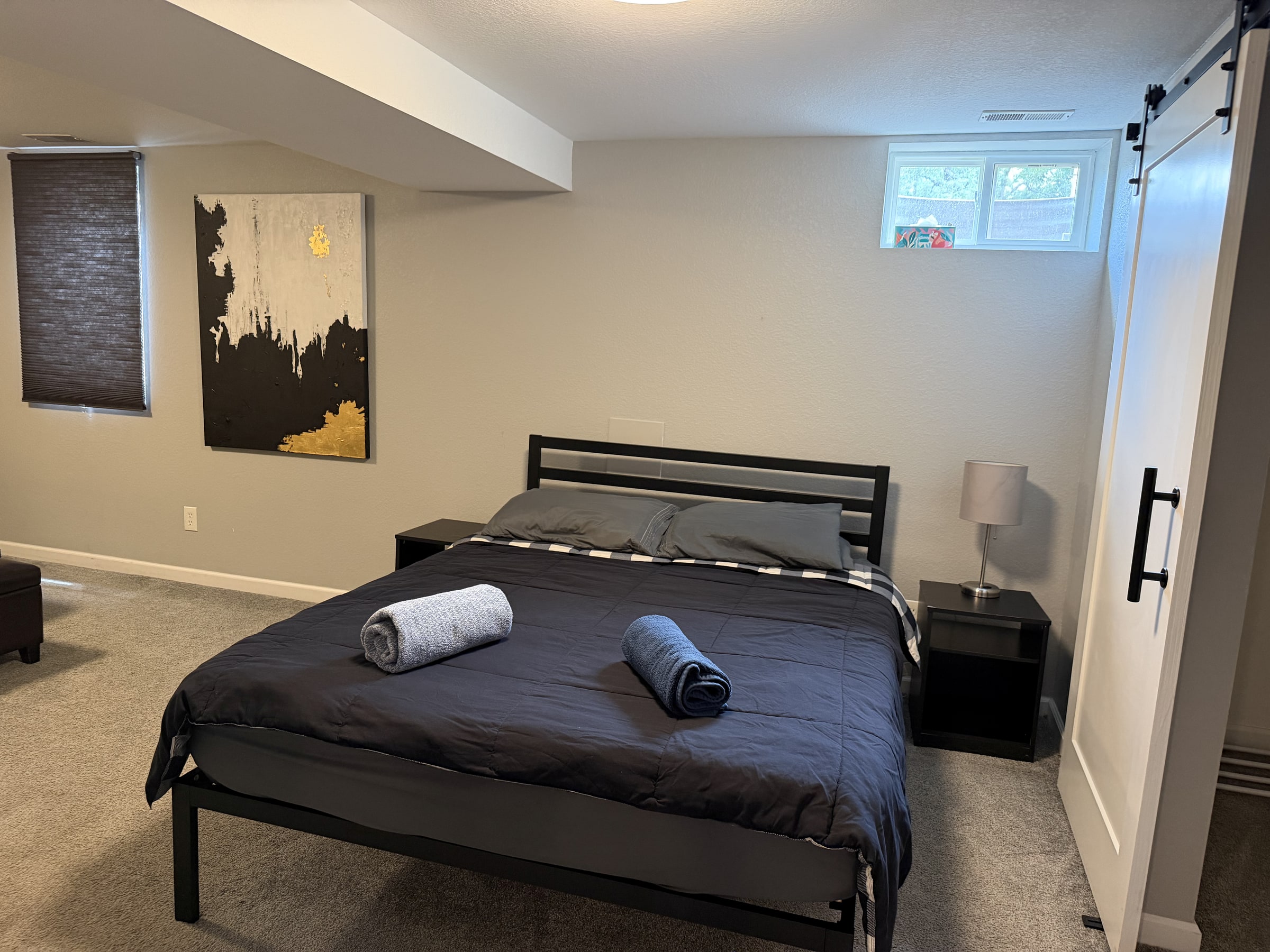Clean bedroom with dark bedding and folded towels