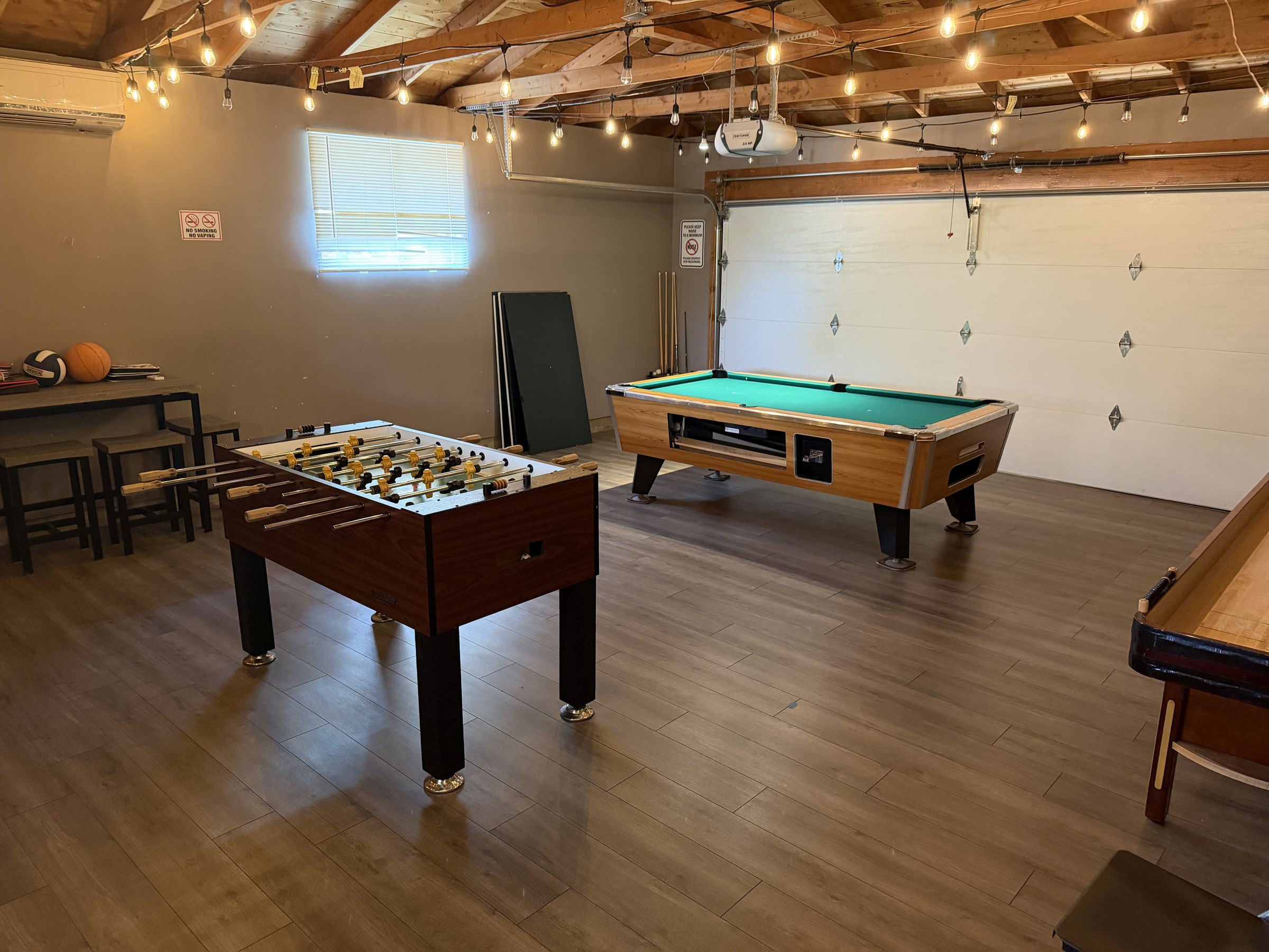 Large game room with pool table, foosball, and clean floors