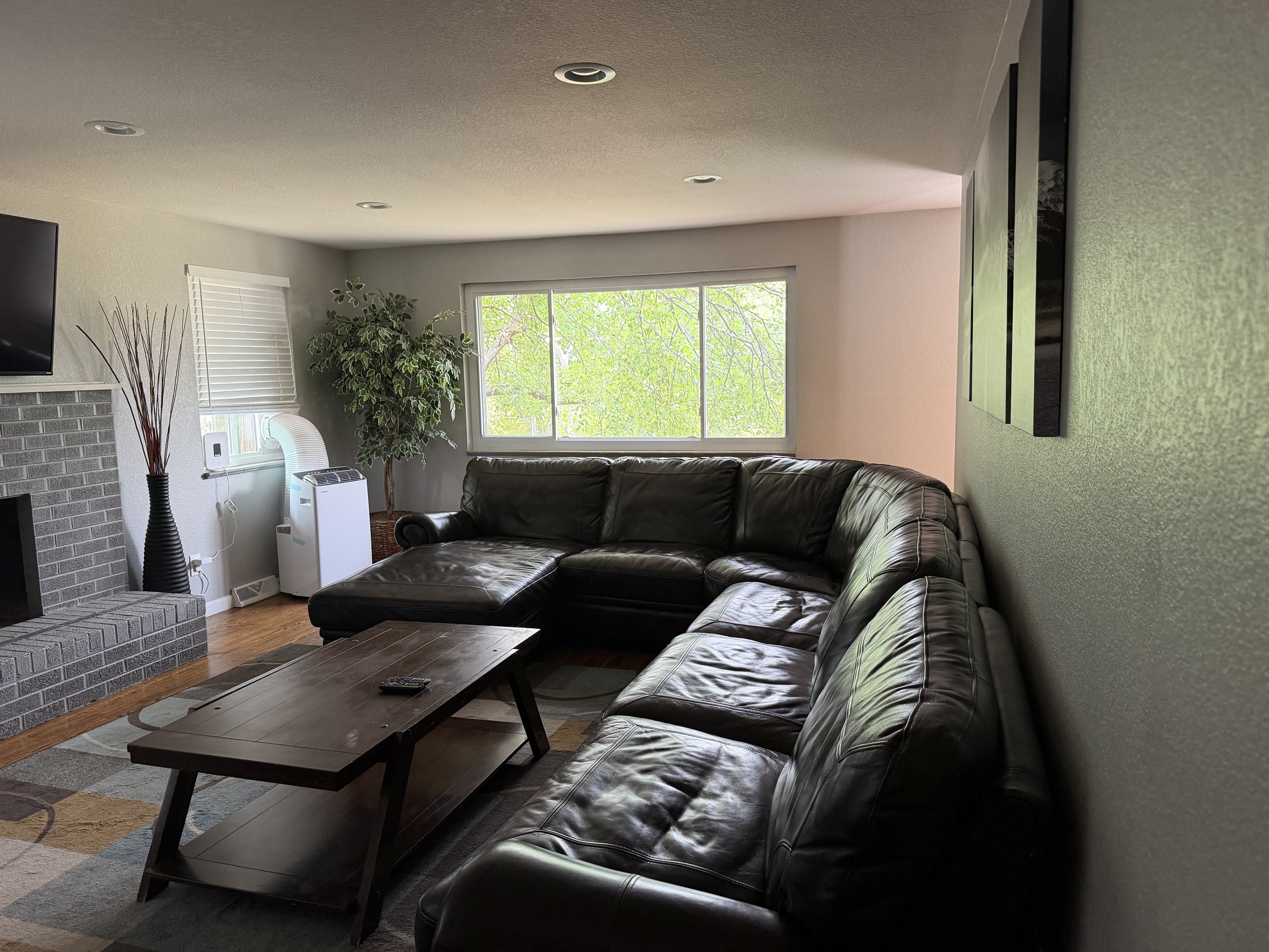 Living room with black leather sectional and clean floors