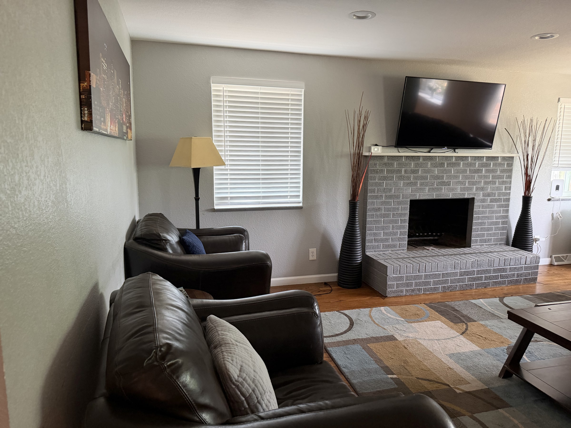 Living room with leather chairs, fireplace, and tidy surfaces