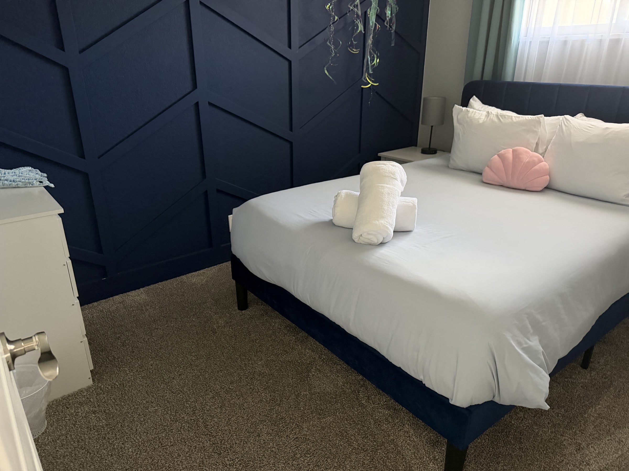 Bedroom with navy accent wall and crisp white bedding