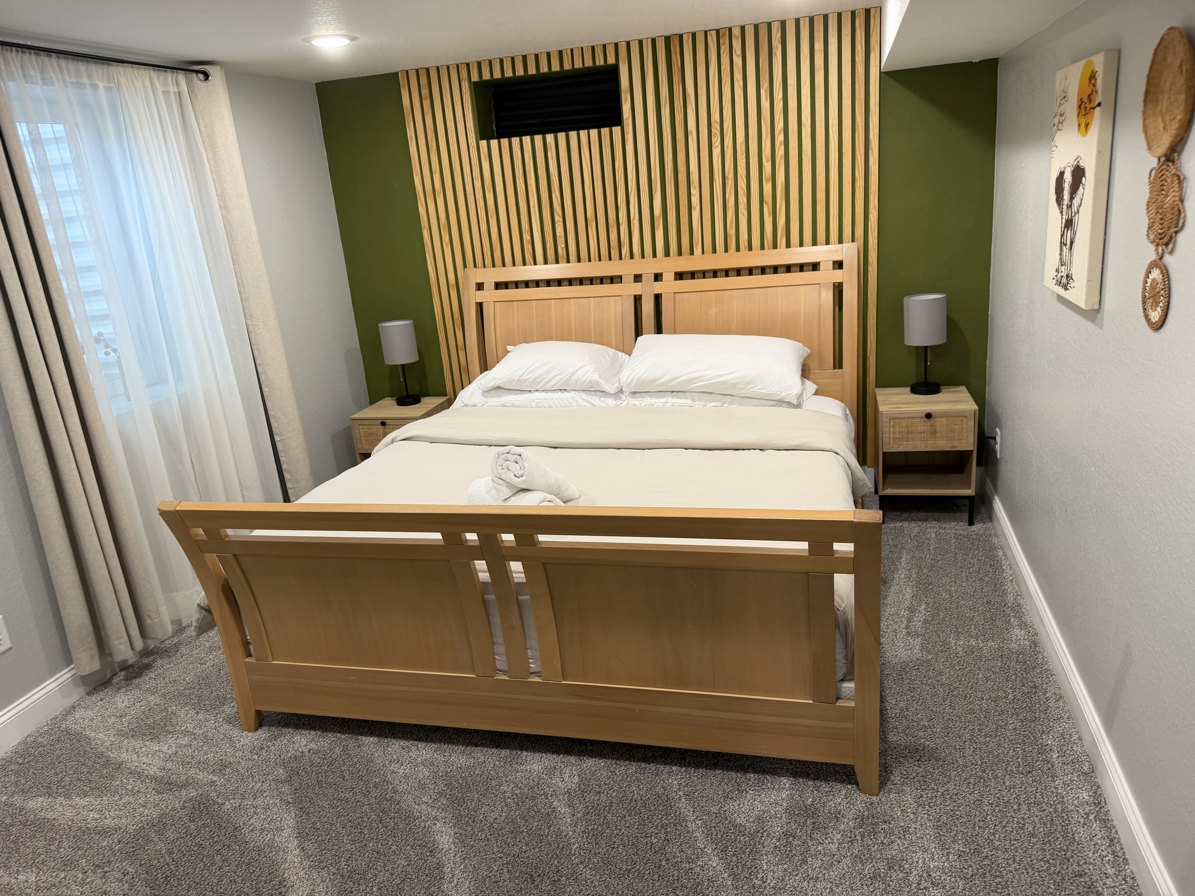 Bedroom with wood bed frame and green accent wall