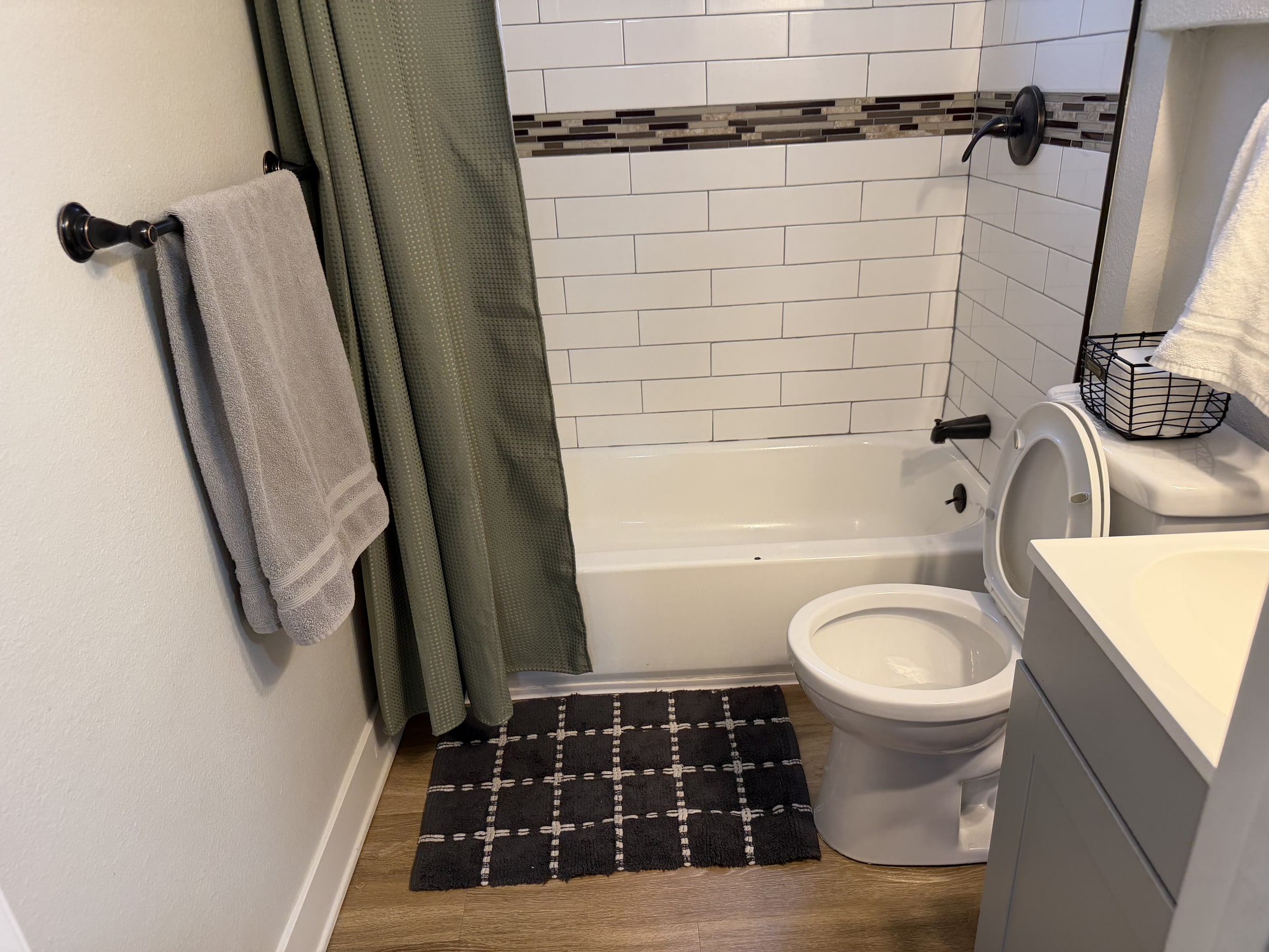 Bright bathroom with white tile tub surround and clean fixtures