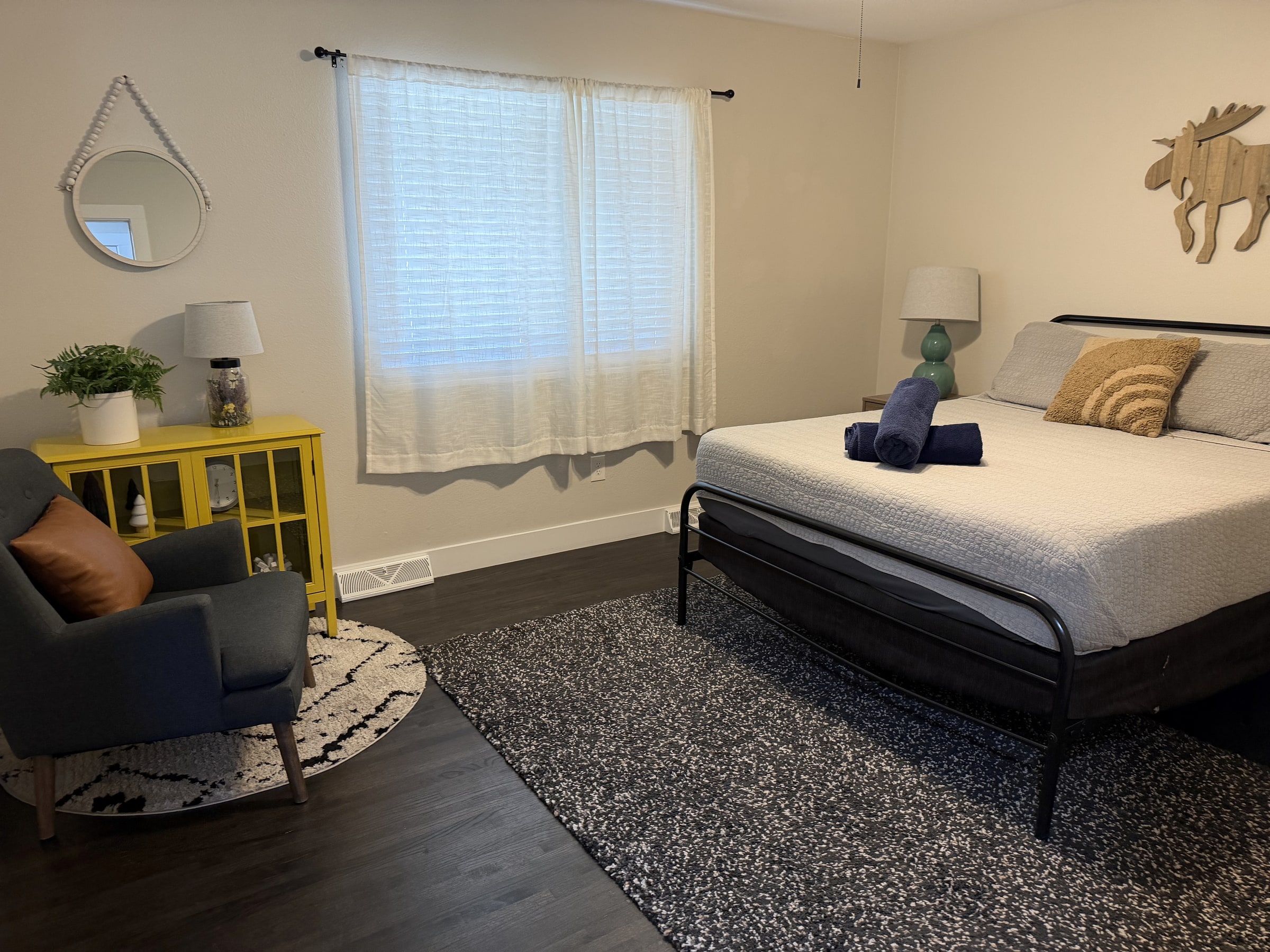 Bedroom with gray bedding, gold accents, and clean floors